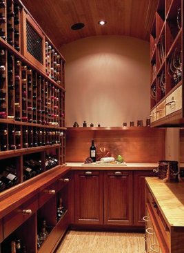 Designer Sherry Hanan recommended mahogany as the dominant wood for its durability in humidity and its upscale appearance. The counter top on the right is made from the clientsí maple kitchen table. LED lighting is hidden under the cabinets. The copper shelving (on rear wall), backsplash and metal drawer liners were custom made by Corley Roofing & Sheet Metal. The floating cork floor is from WE Cork Avant Garde collection. 