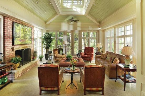 During the day, light floods into the addition through the walls of windows and cupola. A masonry fireplace ensures the room can be used in cold weather as well.