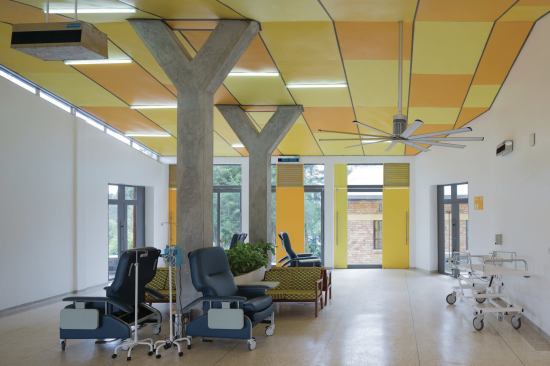 In the infusion room, patients can sit with family members in custom furniture that sits on SAJ floor tile while they receive their treatment. Large-scale doors can open to the outside to promote cross-breeze from the Big Ass Fans fixture installed overhead. 