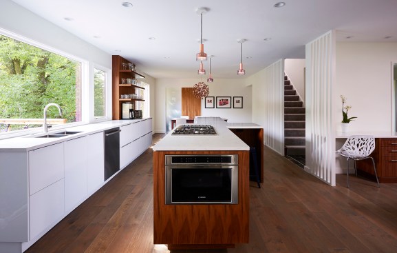 CityDeskStudio celebrates the Mediterranean style of this 1960s home. Copper light fixtures give the remodeled kitchen a contemporary look.