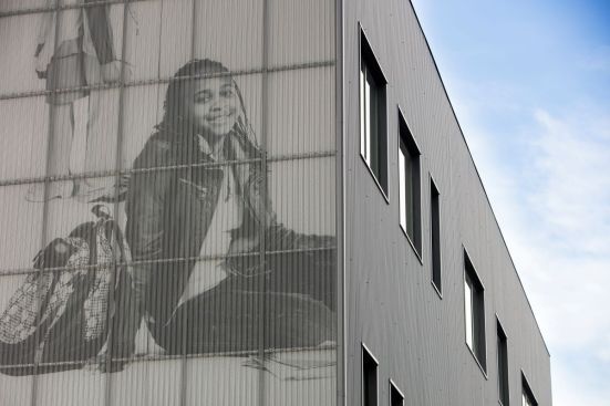 Moving Everest Charter School uses perforated aluminum panels to provide a cost-effective, visually unique façade.