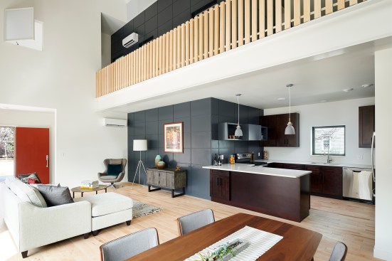 A double-height living and dining room and connected kitchen serve as the core of the house.