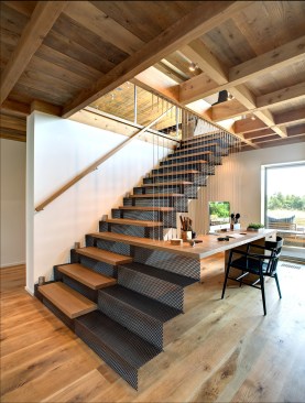 Architect Paul Masi wanted a “light, airy, and sculptural” look for the
stairs. Breitenbach
built it with risers made of the perforated blackened steel and white oak
treads, then installed it on site. The desk is suspended by a metal
cable railing system.&nbsp;