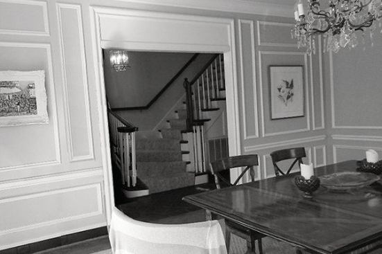 BEFORE: The existing view from the dining room to the main entry. The stairs, which turned out at the bottom, interrupted the flow down the hallway.