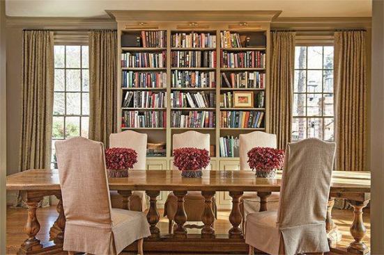 Custom bookcases between the windows and surrounding the entry door harken back to great libraries of the past while adding color and movement to the neutral palette in the room.