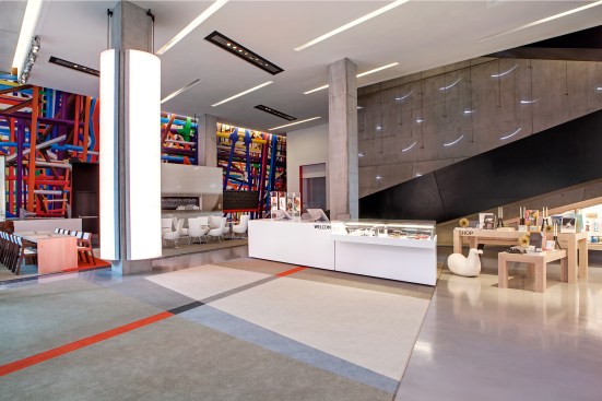 The renovated lobby and new store. Left back-wall mural by Vivid Astro Focus, right back-wall light installation by Erwin Redl, and column wrap by Vulkane.&nbsp;