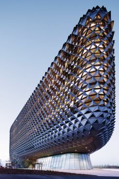 The building’s distinctive form was determined in part by site constraints, including the desire to create plaza-level connections between urban fabric on one side and a riverwalk on the other.