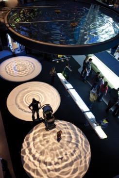 Liquid Wave Dynamics are shown with spotlights shining 60 feet down through large liquid-filled disks to project ripple patterns on the floor.