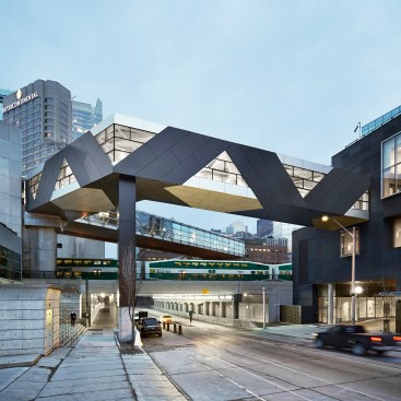 Developed in a collaboration with artists Jennifer Marman and Daniel Borins and Toronto-based firm Page + Steele/IBI Group Architects, the SFC Bridge in Toronto is a pedestrian walkway that connects the new Delta Hotel to the Metro Toronto Convention Centre. Clad in dark- and light-colored aluminum panels, the bridge features triangular windows that create geometric patterns of light and shadows inside.
