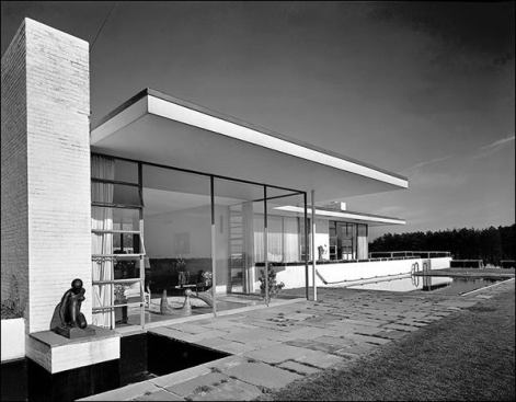 A. Conger Goodyear House, Old Westbury N.Y.
Edward Durell Stone  Photographer: Ezra Stoller &copy; Esto  Formally, the house fuses Miesian minimalism with the Prairie Style of Frank Lloyd Wright, evidenced in the house’s deep overhangs. Reflecting on the house’s eaves in his 1962 memoir, 
The Evolution of an Architect, Stone writes, “Not only is the overhanging eave an important practical consideration, but I find it aesthetically mandatory on a house with a flat roof, satisfying visually the desire for certain aspects of the pitched roof so long associated with residential architecture.”