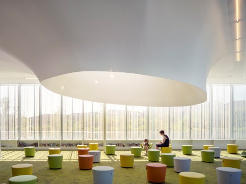 The children’s reading area is a carpeted space at the northwestern corner of the building; vertical ceramic fritting on the curtain wall helps to limit solar gain and glare, and to help the building meet targets for LEED Gold certification.