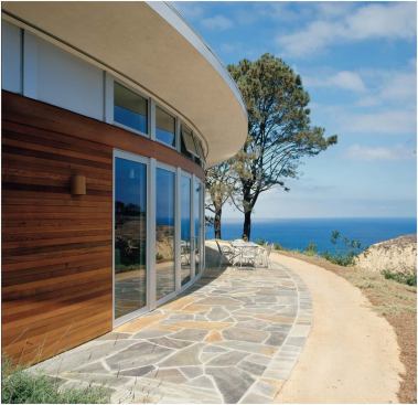 As with many of the firm’s houses, the quiet front elevation of this La Jolla, Calif., residence (below, left) gives way to a dramatic rear fa&ccedil;ade (left and below). Clerestory windows let sunlight spill into the interiors.