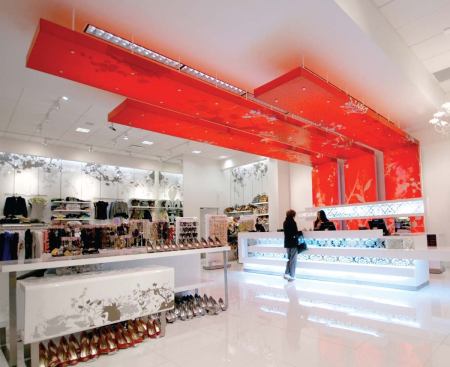 There are a few architectural moments in the Love Culture store that marry lighting and form. At the cash register counter, recessed fluorescent lighting backlights a red canopy to create a focal point in the space.