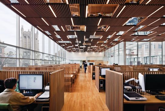 The engineering library has a wood-slat ceiling that again mimics the striations of the etched façade panels. Inset mirrored panels reflect the students working and also reflect daylight to brighten the space.