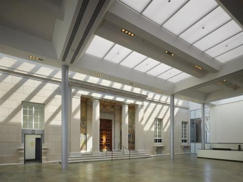The original 1929 fa&ccedil;ade is preserved in a winter garden linking the south addition to the existing structure. Used as an event space, a caf&eacute;, and a welcome daylit respite from hard New Hampshire winters, the space features a large central skylight that contains two layers of perforated stretch vinyl fabric from NewMat, which help to cut down on glare and dampen the reverberant acoustics.