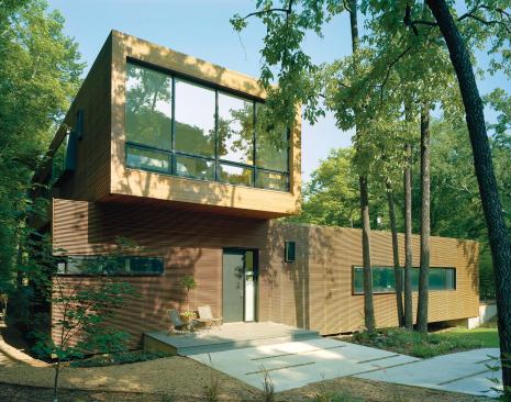 Only the first floor and the short end of the second floor are visible from the street, helping the project fit into its context of one-story cottages and ranch houses.