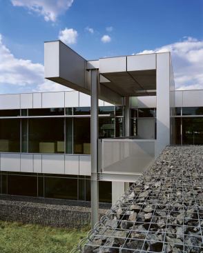 A steel-framed pavilion provides an outdoor sheltered terrace overlooking a restored wetland.