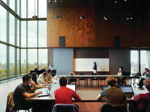 The penthouse-level performance hall in the tower can serve as a classroom, a rehearsal space, or a music venue. Micro-perforations in the walnut-lined walls expose acoustic material that absorbs sound.