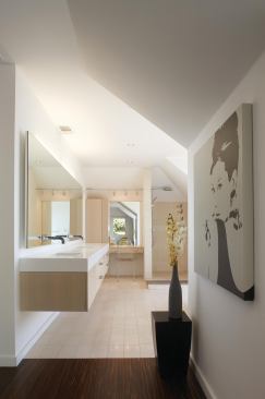 The master bathroom features a solid surface vanity atop a rift-cut white oak base. Limestone tiles line the floor and shower, while an ipe "rug" is set into the  floor.

