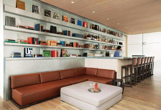 The second floor bar provides a more casual place for guests to linger. Departing from the dark tones of the ground floor spaces, Citterio here turned to lighter woods and a metal paneling system for the walls and built-in bookshelves. Client Klaus Ortlieb, a bibliophile, wanted to include books as part of the décor in an effort to create what he calls a “homey” environment. And books there are—in the lobby library, guest rooms, and even the upstairs bar (shown here).