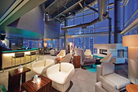 The interior of the rooftop lounge draws a trendy crowd with its open floor plan and high industrial metal ceiling with exposed duct work. Floor-to-ceiling glazing offers an expansive view of the Loop. The lounge’s mod vibe fits in with the hotel’s other boutique attributes, which were a departure for its normally staid parent chain, Doubletree.