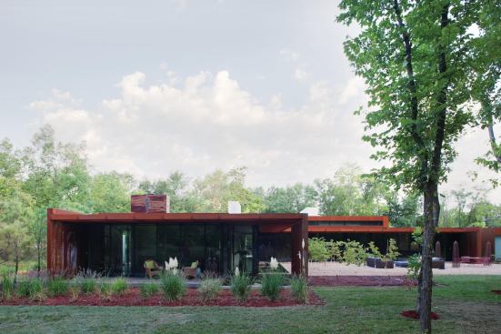 The back of the house is almost completely transparent. Sliding doors pocket into walls, opening up the house in pleasant weather.