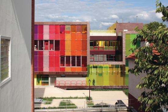 The brightly glazed Youth Center and Sports Complex in Saint-Cloud, France, is constructed from an articulated ribbon of stuctural, load-bearing, prefabricated concrete panels. This allowed for quick construction and was an experiment for Paris-based KOZ Architects, which had not previously worked with the material.