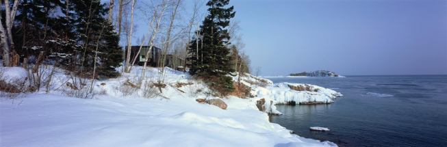 The main house and studio are pulled apart to frame a view of the lake.  
