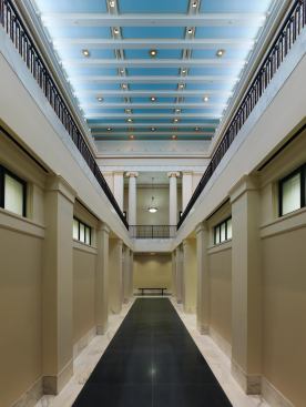 Inside, the first-floor lobby is lined with Doric pilasters.