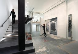 A folded wood wall helps define the gallery space.