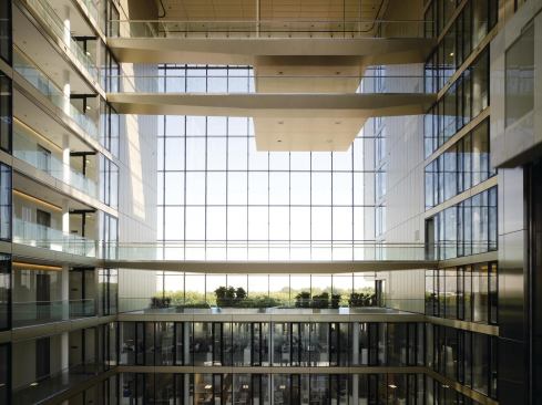 To regulate temperature in the non-climate-controlled atrium, the design team employed skylights that release pent-up hot air and promote passive ventilation. Plants are set out on the bridges that traverse the space, and a garden is installed at the base so that workers who have offices looking into the atrium have a view that includes greenery.