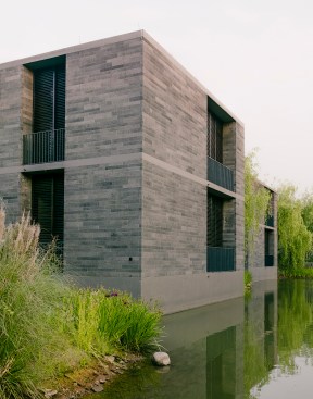 Deeply inset balcony windows provide three levels of protection: wooden louvers for sun, mesh fabric for mosquitoes (particularly important in a wetland), and sliding glass doors.